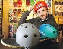  ?? DARREN MAKOWICHUK ?? Bjorn Julson dons a helmet at his Calgary shop, The Source Snowboard and Skates, on Wednesday.