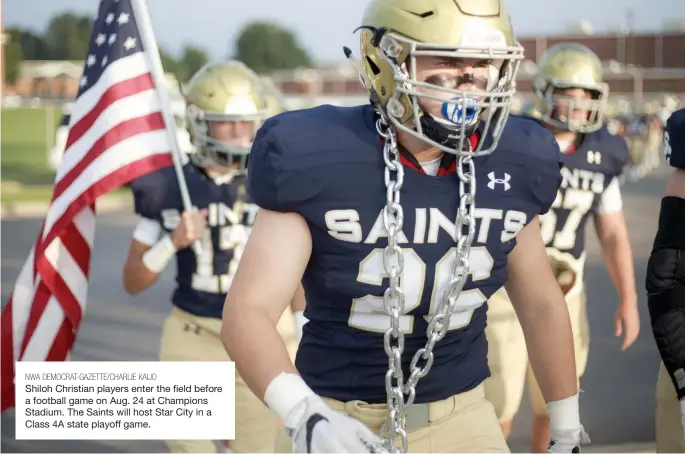  ?? NWA DEMOCRAT-GAZETTE/CHARLIE KAIJO ?? Shiloh Christian players enter the field before a football game on Aug. 24 at Champions Stadium. The Saints will host Star City in a Class 4A state playoff game.