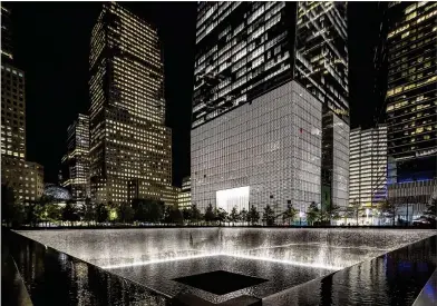  ?? BRIAN CASSELLA/CHICAGO TRIBUNE/TNS ?? The September 11 Memorial North Pool and One World Trade Center at night on Oct. 8, 2014, in New York.