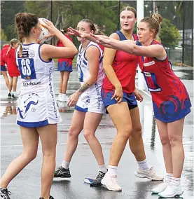  ?? Photograph­s by AMANDA EMARY. ?? Above: Buln Buln goal defence Erin Smethurst defends the shot of Neerim South goal shooter Nicole Alcock during wet conditions in A grade. Neerim, the reigning premiers, had a strong 40-21 win.