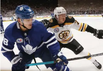  ?? GETTY IMAGES ?? ‘STAY IN THE MOMENT’: Bruins defenseman Charlie McAvoy, right, checks Toronto Maple Leafs forward Andreas Johnsson on Friday night.