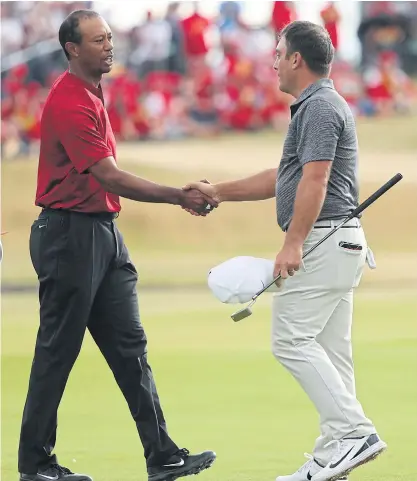  ??  ?? Francesco Molinari, right, and Tiger Woods shake hands on the 18th hole after the final round of the 147th British Open.
