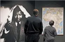  ??  ?? Visitors look at a map of South Africa with red lines outlining Nelson Mandela’s travels in 1962.