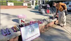  ?? K.T. Mckee ?? Lee Niedrach, chairman of the board of Hospitalit­y House for Women, picks a pair of high heels for the annual Walk a Mile in Her Shoes domestic violence awareness event at Rotary Park and down Broad Street on Friday in downtown Rome.