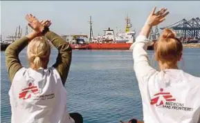  ?? EPA PIC ?? Two women from Doctors Without Borders waving to the ‘Aquarius’ as it enters the port of Valencia in Spain yesterday.