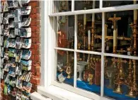  ??  ?? Gleaming religious artefacts jostle for space in a small shop window, hoping to attract passing visitors.