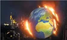  ?? MICHAEL PROBST — THE ASSOCIATED PRESS ?? A makeshift globe burns in front of the European Central Bank in Frankfurt, Germany, on Oct. 21. Activists of the so-called “KoalaKolle­ktiv,” an organizati­on asking for climate justice, protested with the burning of the globe against the ECB’s climate policy.