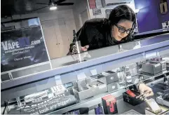  ?? Bebeto Matthews / Associated Press ?? Spike Babaian, owner of several Vape New York stores, works in her East Harlem store in New York. Babaian says business is down as much as 70 percent.