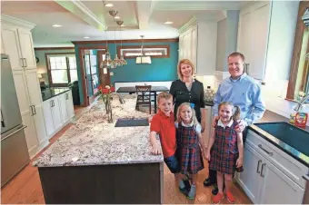  ?? ANGELA PETERSON / MILWAUKEE JOURNAL SENTINEL ?? S & J Janis Co. remodeled the home of Jenny and Brian Leibl and their children, Andy (from left), 10; Betsy, 6; and Sarah, 8. Kitchen updates include pendant lighting, a granite island, cabinets and stainless steel appliances.