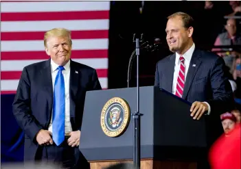  ?? AP PHOTO/AnDREW HARniK ?? In this Oct. 13 photo, president Donald Trump (left) listens as Rep. Andy Barr, R-Ky. (right) speaks at a rally at Alumni Coliseum in Richmond, Ky.