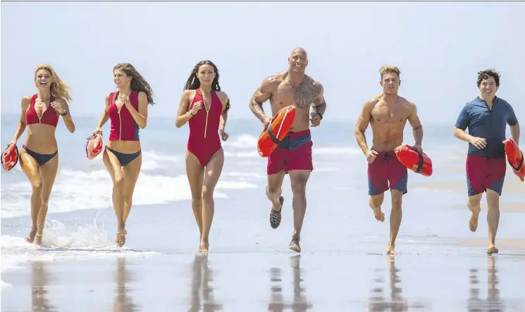  ?? PHOTOS: PARAMOUNT PICTURES ?? Kelly Rohrbach, left, Alexandra Daddario, Ilfenesh Hadera, Dwayne Johnson, Zac Efron and Jon Bass sport the famous Baywatch beach attire in the new film.