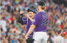  ??  ?? Gray talks with catcher Tony Wolters as a play is reviewed during the July 12 game against the Cincinnati Reds at Coors Field.