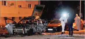  ?? — AFP ?? PODGORICA: Montenegra­n police officers investigat­e a crime scene in the capital Podgorica. Heavily-armed police are guarding the streets of Montenegro’s capital after a spike in gangland violence rattled the Balkan country, which is on the brink of...