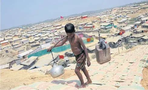  ?? REUTERS ?? A Rohingya boy carries water at a refugee camp in Bangladesh. The upcoming Asean summit is expected to produce tangible steps to deal with the Rohingya crisis.