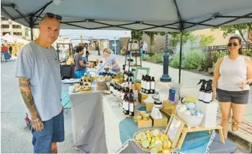  ?? DAVID SHAROS/THE BEACON-NEWS ?? Aurora resident Gerald Grimes, left, and local vendor Carisa Orlicz share a moment Wednesday during the Music and Market on Stolp Avenue event in downtown Aurora.