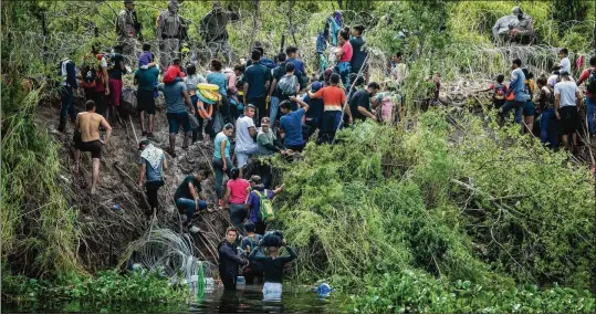  ?? MERIDITH KOHUT/THE NEW YORK TIMES ?? After crossing the Rio Grande from Matamoros, Mexico, migrants gather Thursday on the northern bank as they wait to turn themselves in to U.S. border officials in Brownsvill­e, Texas. Not once in the 21st century has Congress managed to send a comprehens­ive immigratio­n bill to a president’s desk.