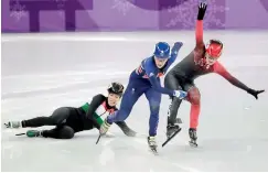  ?? —AP ?? Elise Christie (centre) skates as Andrea Keszler (left) falls and Kim Boutin stumbles during the ladies 500m short track speedskati­ng quarterfin­al in the Gangneung Ice Arena at the Winter Olympics in South Korea.