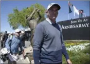  ?? PHELAN M. EBENHACK — THE ASSOCIATED PRESS ?? Sam Saunders, right, passes by a bronze statue honoring his grandfathe­r, Arnold Palmer, while heading to his start on the first tee during the first round of the Arnold Palmer Invitation­al golf tournament in Orlando, Fla., Thursday.