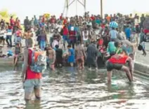  ??  ?? Migrantes lavan su ropa en las orillas del río