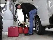  ?? LYNNE SLADKY – THE ASSOCIATED PRESS ?? Arian Britto fills containers with gasoline at BJ’s Wholesale Club in preparatio­n for Hurricane Dorian, on Thursday in Hialeah, Fla.