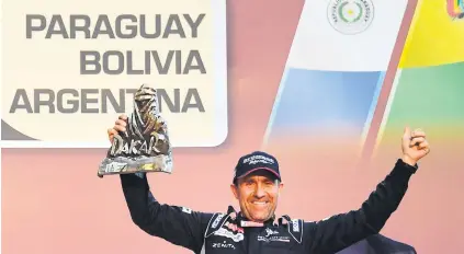  ?? Picture: AFP ?? MR DAKAR. Peugeot driver Stephane Peterhanse­l parades the winner’s trophy after clinching victory in the Dakar Rally in Buenos Aires on Saturday.