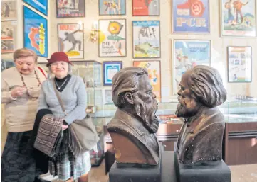  ??  ?? FOUNDER FATHERS OF COMMUNISM: Visitors look at busts of Friedrich Engels, left, and Karl Marx, on display at an auction house in Bucharest, Romania.