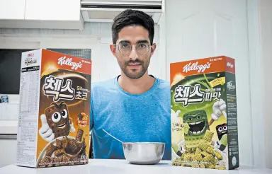  ?? JUWON PARK/AP ?? Journalist Raphael Rashid with a box of green onion-flavored Chex cereal alongside its chocolate counterpar­t in Seoul, South Korea.