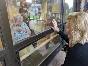  ?? SUBMITTED PHOTO ?? Ella McHenry, left inside, greets visitors gathered outside Zerbe Sisters in Narvon as they wish her a happy 100th birthday.