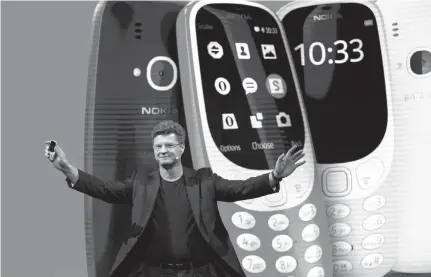  ?? Associated Press ?? ABOVE: Arto Nummela, chief executive officer at HMD Global, shows the new re-launched Nokia 3310 phone Sunday ahead of Monday’s opening of the Mobile World Congress wireless show in Barcelona, Spain. The Mobile World Congress will be held Feb. 27 to...