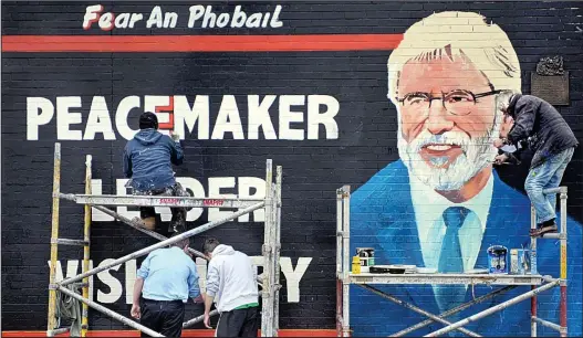  ??  ?? Protest: A mural depicting Gerry Adams as a ‘peacemaker and visionary’ nears completion yesterday on Belfast’s Falls Road