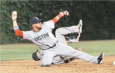  ??  ?? SINSINTONÍ­A. El boricua Mike Avilés se apresta a tirar a la inicial, mientras su compañero Dustin Pedroia está en el suelo. Ambos jugadores chocaron al cubrir la segunda base.