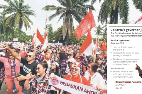  ?? AFP Photo: Goh Chai Hin ?? Supporters of Jakarta governor Basuki Tjahaja Purnama alias Ahok dance outside North Jakarta. — AFP photo