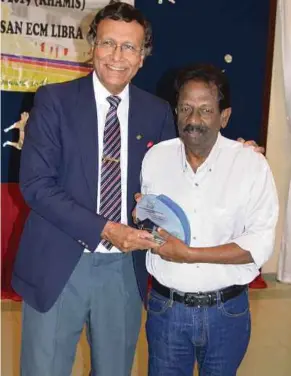  ??  ?? Sabapathy Sinnayah receiving his award from SPI board of directors chairman Dr Bob Samuel. PIC BY S. SOLOMON SAMUEL