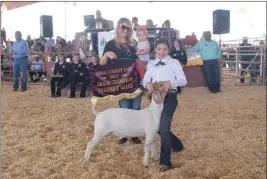  ??  ?? MADISON MORRIS (FAR RIGHT) shows her Grand Champion Market Goat that was sold to Alexander Auto Center for $35 per pound.