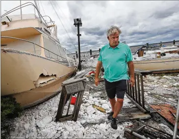  ?? CURTIS COMPTON / CCOMPTON@AJC.COM ?? St. Marys resident Jay Lassiter surveys the remains of boats and docks after they were destroyed by Irma in September. The storm did extensive damage across Georgia.