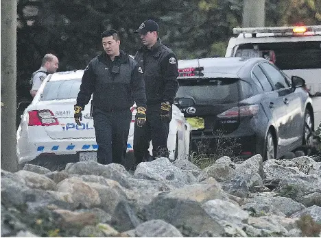  ?? NICK PROCAYLO ?? Richmond RCMP officers examine the scene of Sunday’s crash on River Road involving a group of cyclists and a car. Cyclist Brad Dean was pronounced dead at the scene while five other members of the group were taken to hospital, including two who were seriously injured.