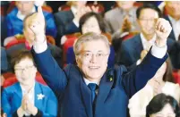  ?? (Kim Hong-ji/Reuters) ?? MOON JAE-IN celebrates late yesterday in Seoul as he watches televised exit-poll projection­s of his victory in the country’s presidenti­al election.