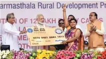  ?? - PTI/PIB ?? ELATED: Prime Minister Narendra Modi distributi­ng the RuPay card to a beneficiar­y at the Shri Kshetra Dharmastha­la Rural Developmen­t Project, at Ujire in Karnataka on Sunday. Union minister Ananth Kumr is also seen.