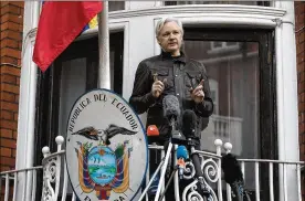  ?? JACK TAYLOR / GETTY IMAGES 2017 ?? Julian Assange speaks to the media from the balcony of the Ecuadorean Embassy in London last May. His lawyers asked for a warrant to be revoked because he is no longer wanted for questionin­g in Sweden over alleged sex crimes.