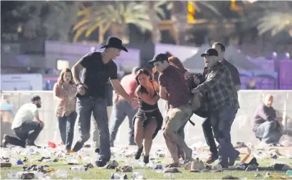  ?? Picture:Getty Images ?? HELPING HANDS. People carry a person at the Route 91 Harvest country music festival after Sunday’s shooting in Las Vegas, Nevada.