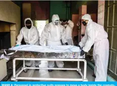  ??  ?? MANILA: Personnel in protective suits prepare to move a body inside the crematory chambers at a crematoriu­m facility on April 29, 2020.