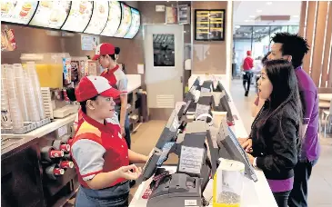  ??  ?? BELOW Customers order food in a Jollibee branch in Pasig City, Manila.