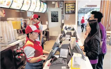  ??  ?? BELOW Customers order food in a Jollibee branch in Pasig City, Manila.