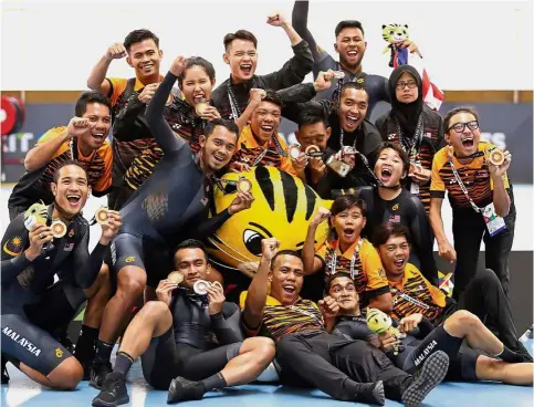  ??  ?? Unpreceden­ted glory: The national track cyclists celebratin­g their wins at the National Velodrome in Nilai on Monday. Malaysia made a clean sweep of all the 12 track golds.