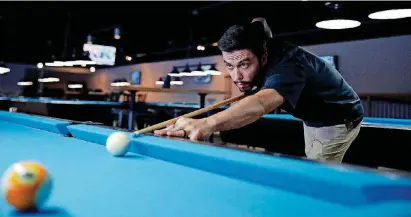  ?? [PHOTO BY SARAH PHIPPS, THE OKLAHOMAN] ?? Nathan Toland shoots pool at The Bridge in Edmond on Tuesday.