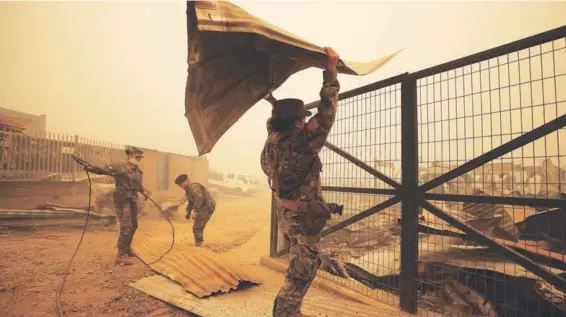  ??  ?? ► Personal del Ejército ayudando en las labores de remoción de escombros en Santa Olga, Región del Maule.