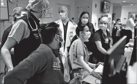  ?? TERRENCE ANTONIO JAMES/CHICAGOTRI­BUNE PHOTOS ?? Dr. Elif Yucebay, seated center, and other medical staff at Rush University Medical Center in Chicago conduct patient reviews Friday.