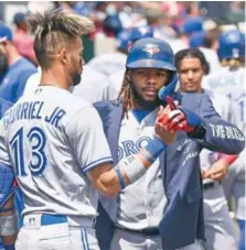  ?? ?? Guerrero Jr., con el traje, es felicitado por Lourdes Gurriel Jr., tras pegar su HR.
↑