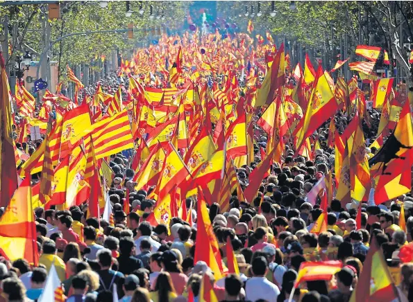  ?? Picture: PIERRE-PHILIPPE MARCOU/AFP ?? Spanish and Catalan flags fill the streets of Barcelona yesterday in a mass rally organised by protesters opposed to independen­ce for Catalonia