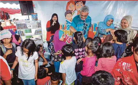  ?? PIC BY SADDAM YUSOFF ?? Federal Territorie­s Minister Khalid Abdul Samad greeting children after launching the Kuala Lumpur Federal Territorie­s’ ‘Kenduri Rakyat’ event in Bandar Tun Razak, Kuala Lumpur, in conjunctio­n with the Federal Territorie­s Day celebratio­n.